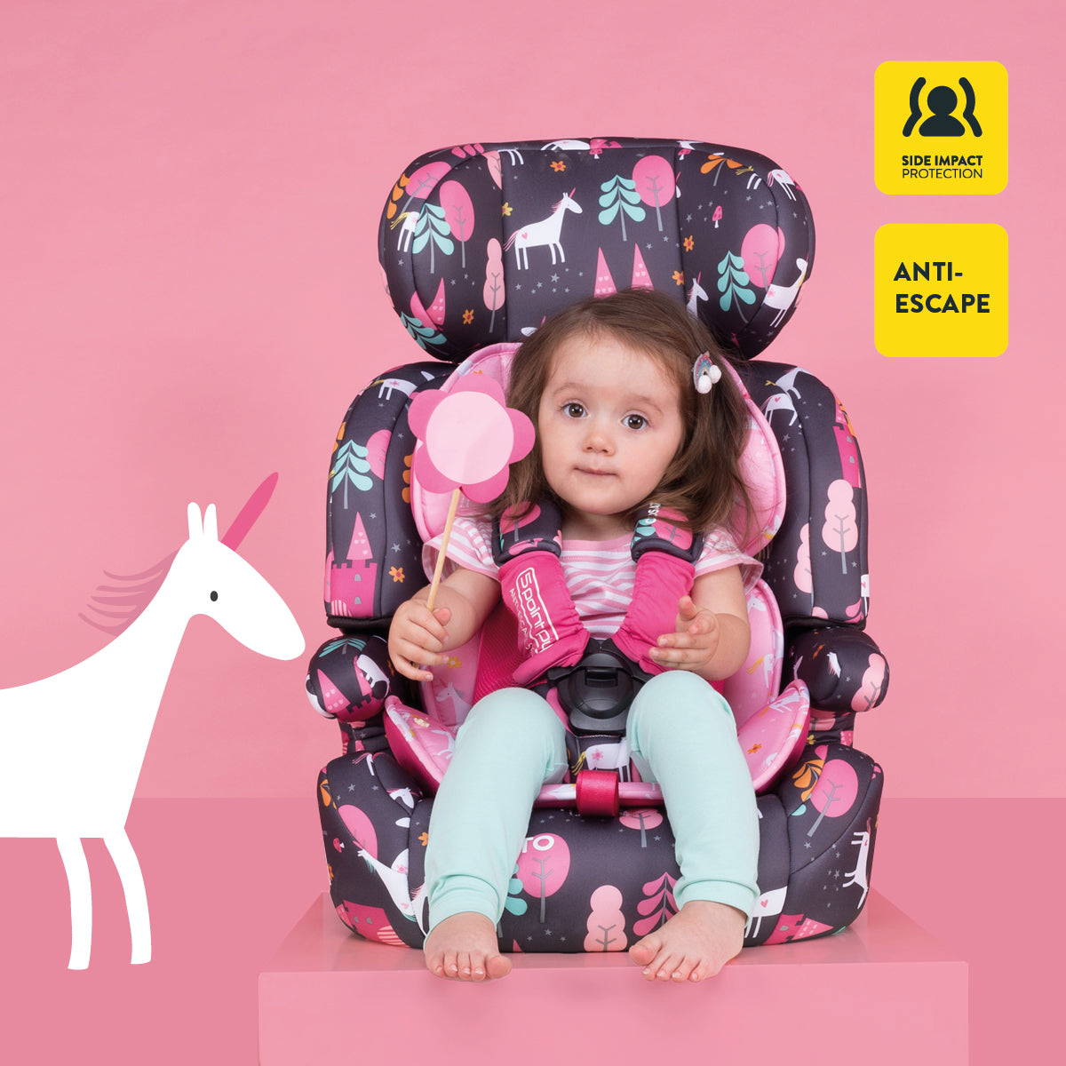 Child in a colorful safety seat with pink background